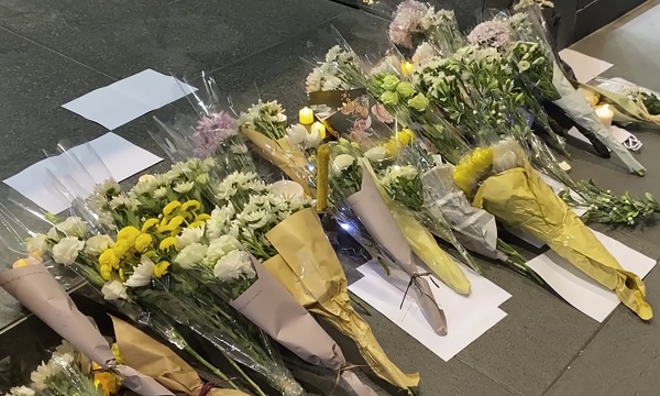 Blank white papers and flowers are laid down during a commemoration for victims of a recent Urumqi deadly fire in Central, a business district in Hong Kong, on Monday.